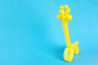Giraffe figure made of modelling balloon on color background. Space for text