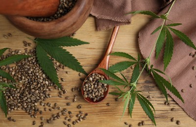 Photo of Flat lay composition with hemp seeds and leaves on wooden table