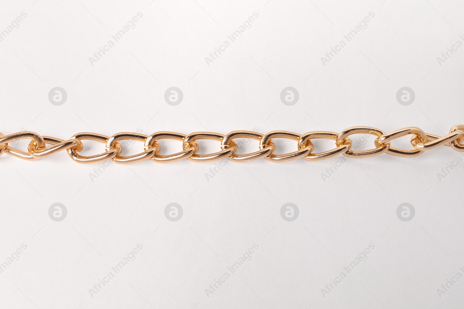 Photo of One metal chain on white background, top view. Luxury jewelry
