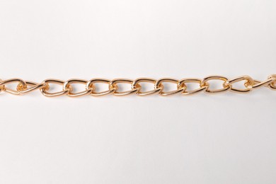 One metal chain on white background, top view. Luxury jewelry