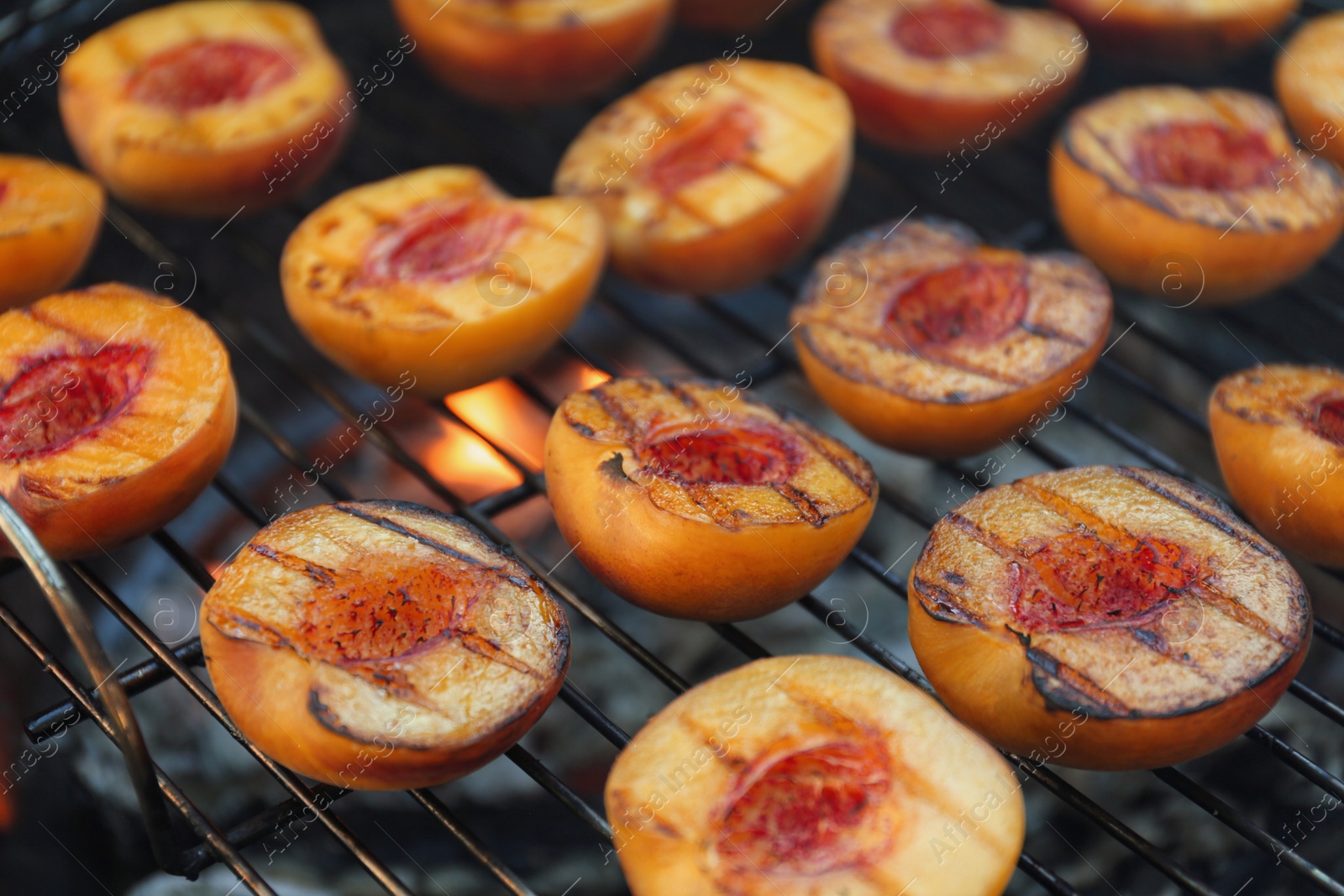 Photo of Modern grill with tasty cut peaches, closeup