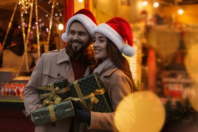 Lovely couple with Christmas presents at winter fair