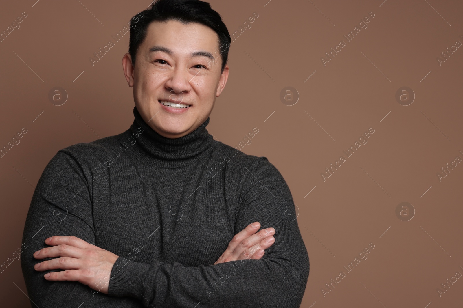 Photo of Portrait of happy man on brown background. Space for text