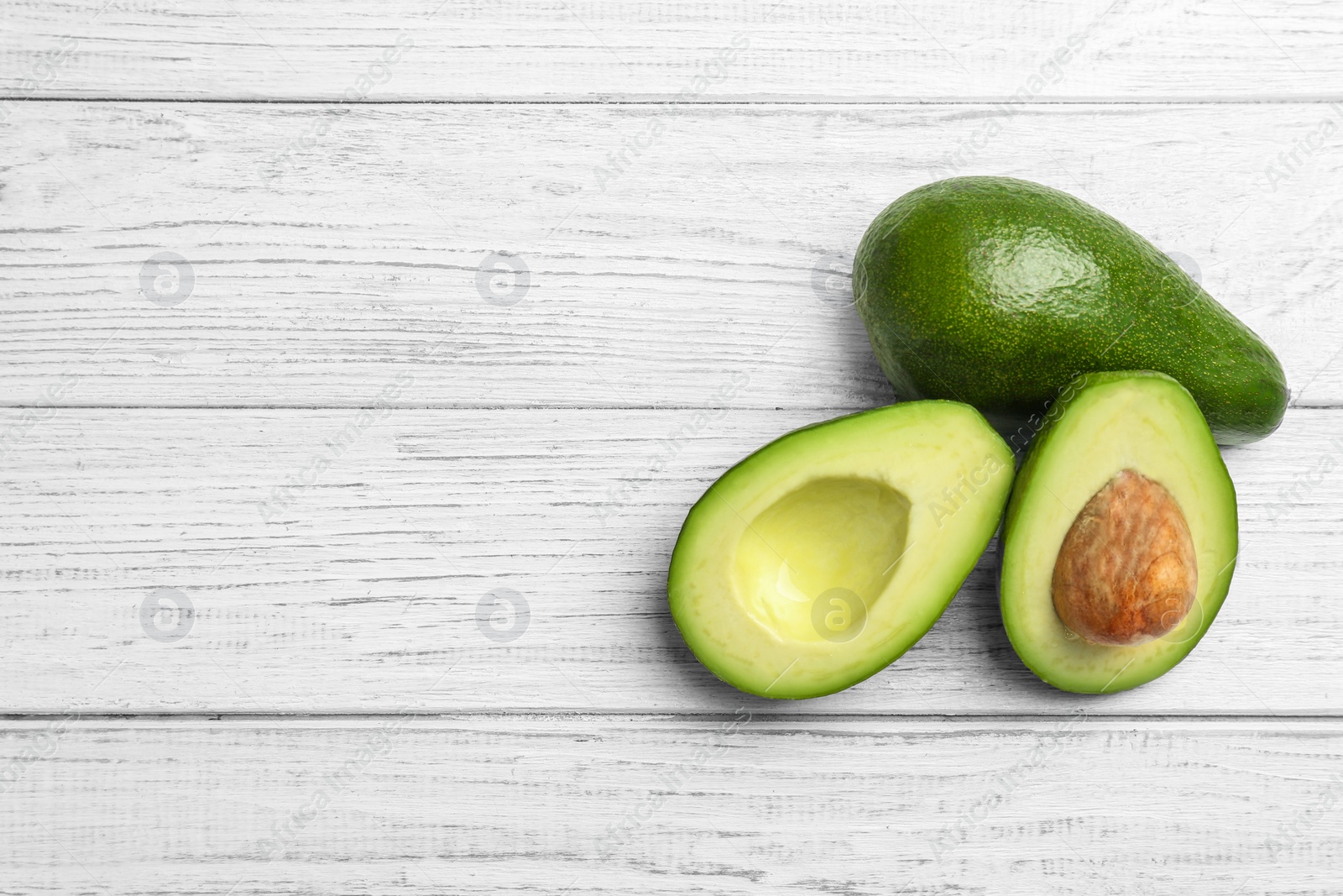 Photo of Tasty ripe green avocados on wooden background, top view