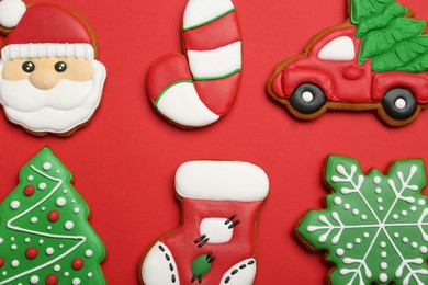 Different tasty Christmas cookies on red background, flat lay