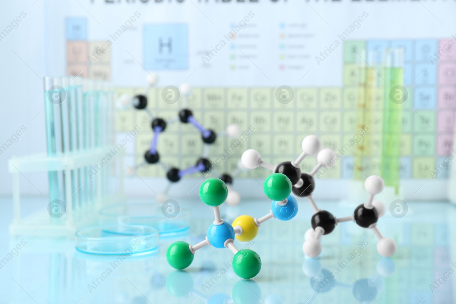 Photo of Molecular model and laboratory glassware on light surface