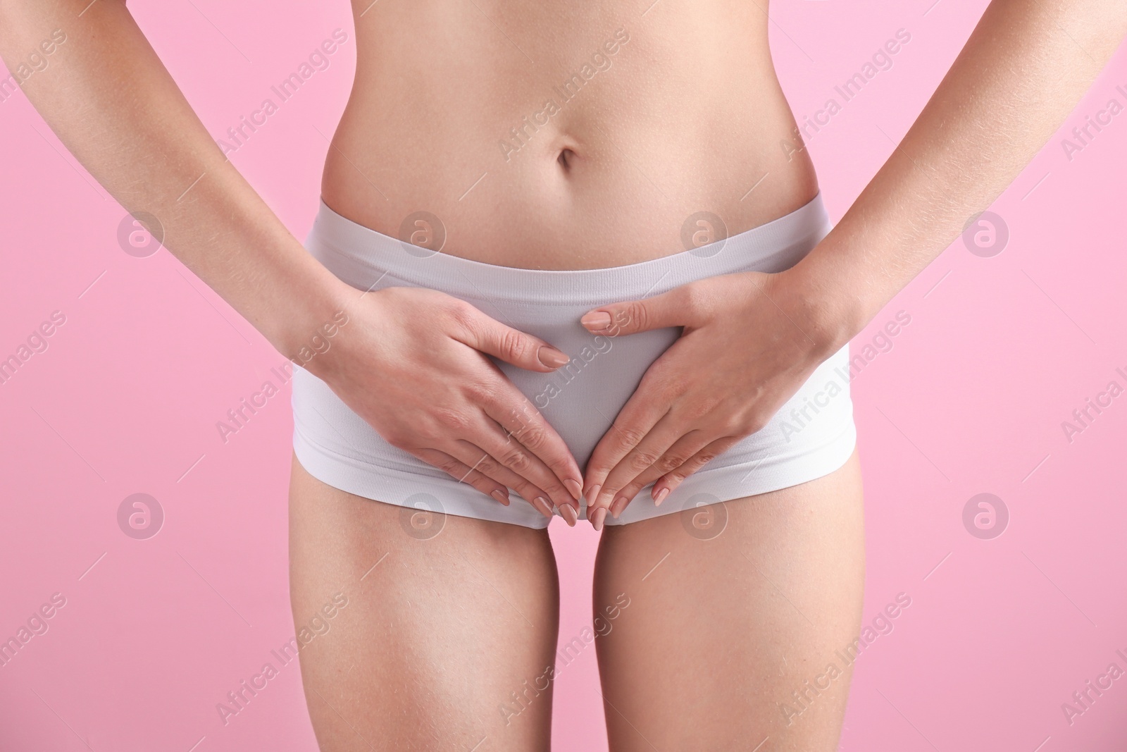 Photo of Young woman holding hands near underwear on color background. Gynecology