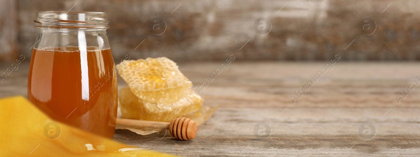 Image of Jar of tasty fresh honey and dipper on table, space for text. Banner design