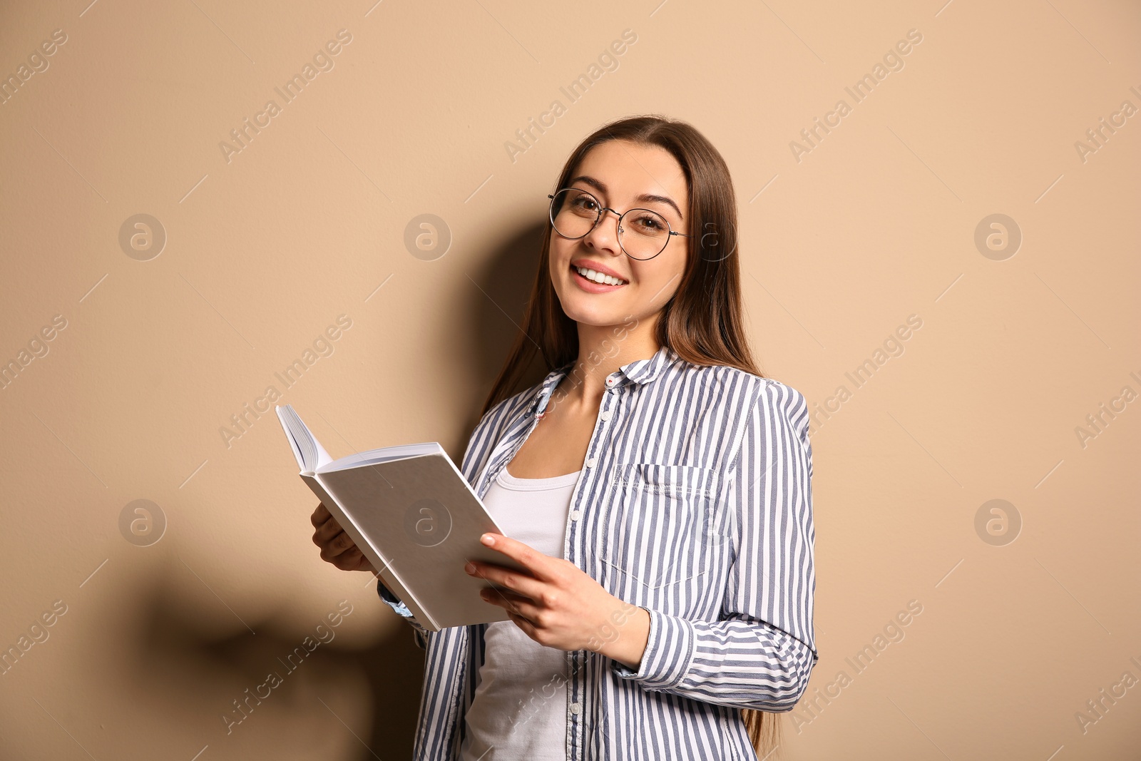 Photo of Young woman with book on color background, space for text