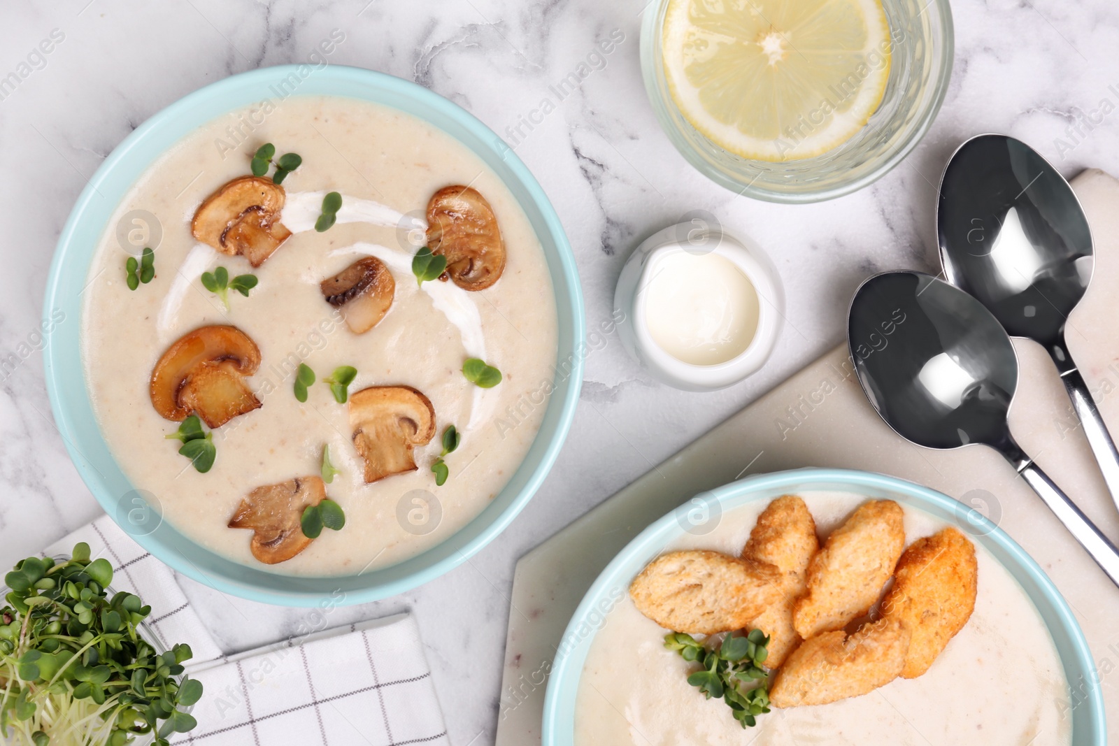 Photo of Delicious cream soup with mushrooms served on white marble table, flat lay