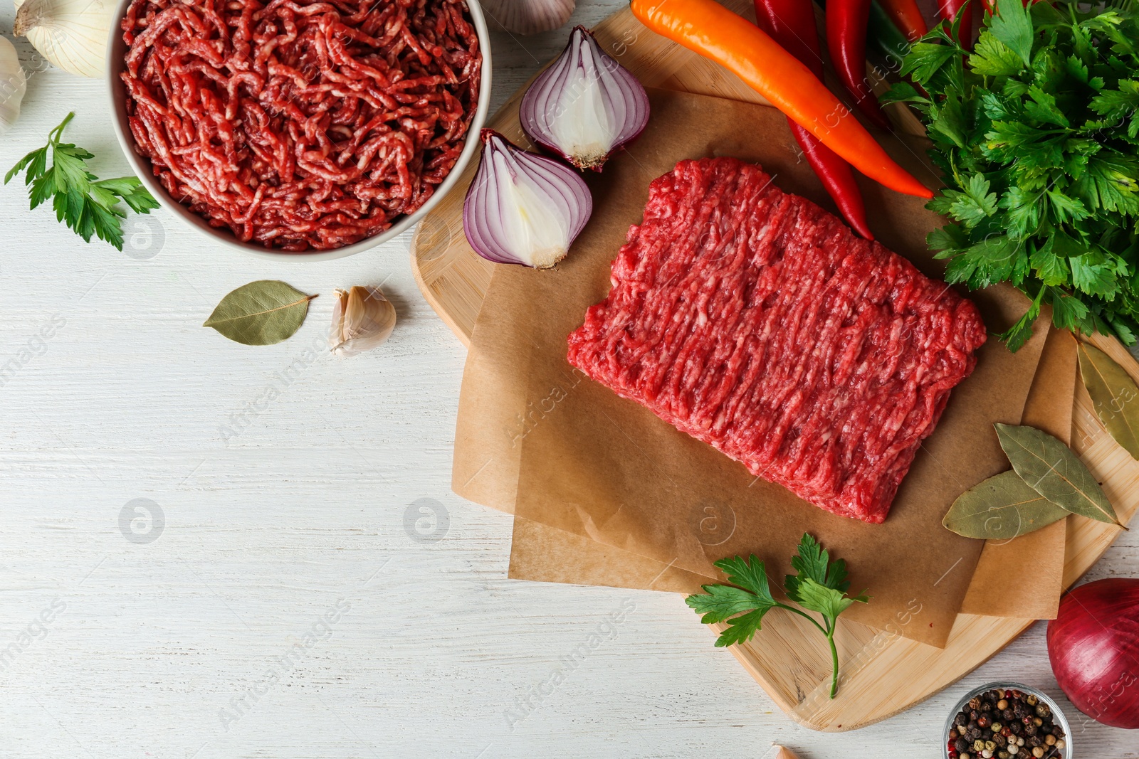 Photo of Flat lay composition with fresh raw minced meat on white wooden table. Space for text