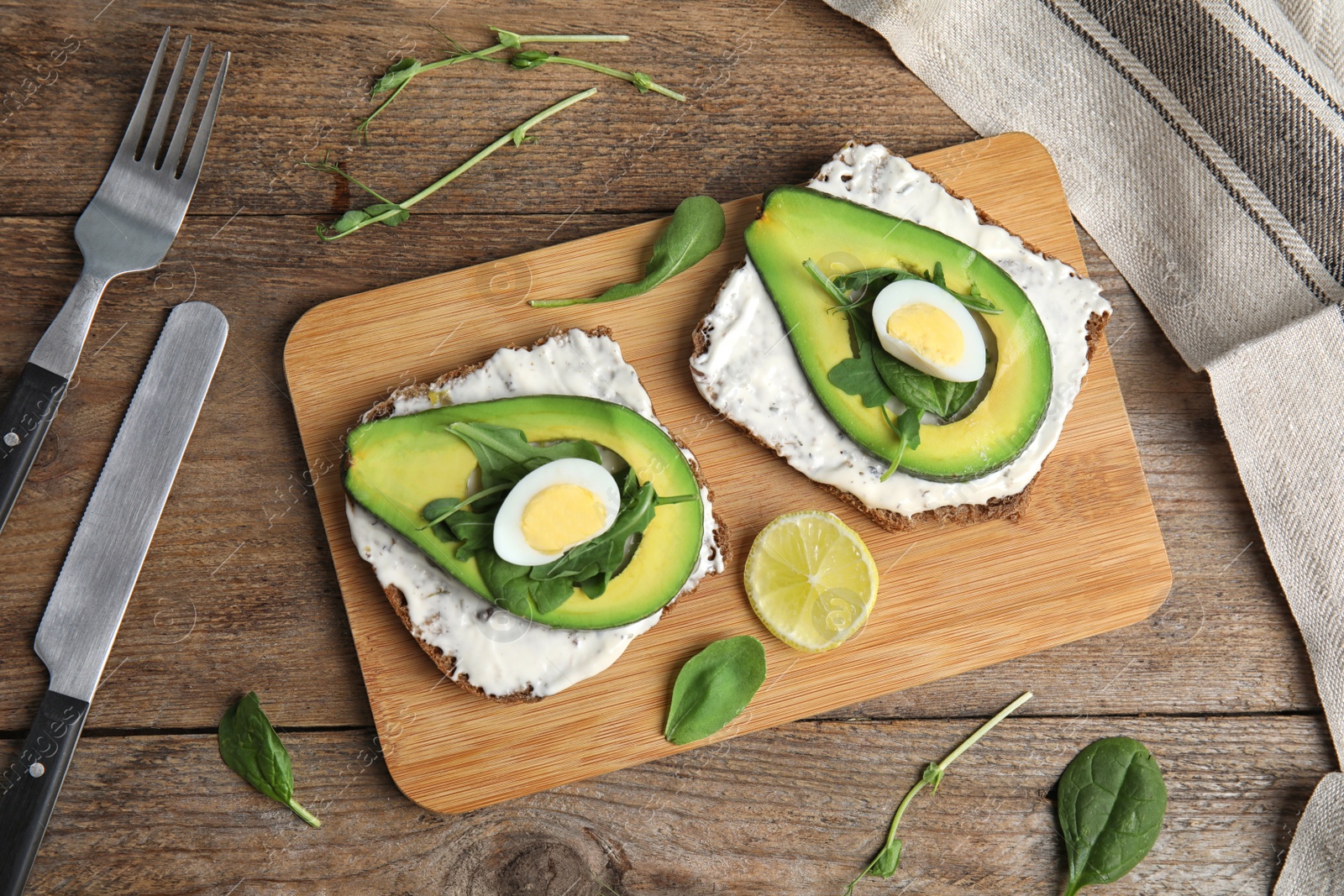 Photo of Flat lay composition with avocado toasts on wooden table