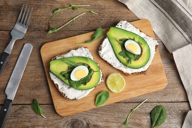 Photo of Flat lay composition with avocado toasts on wooden table