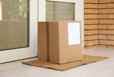 Photo of Delivered parcel on door mat near entrance