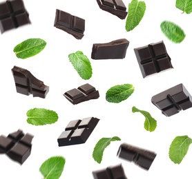 Image of Black chocolate pieces and mint falling on white background