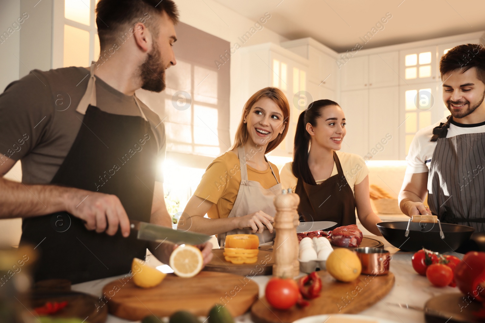 Photo of Happy people cooking food together in kitchen