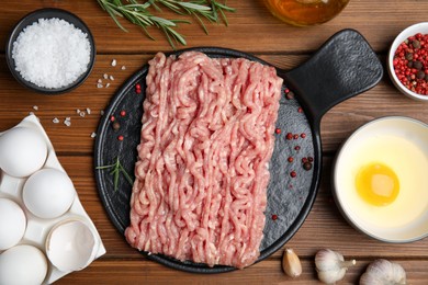 Photo of Raw chicken minced meat and ingredients on wooden table, flat lay
