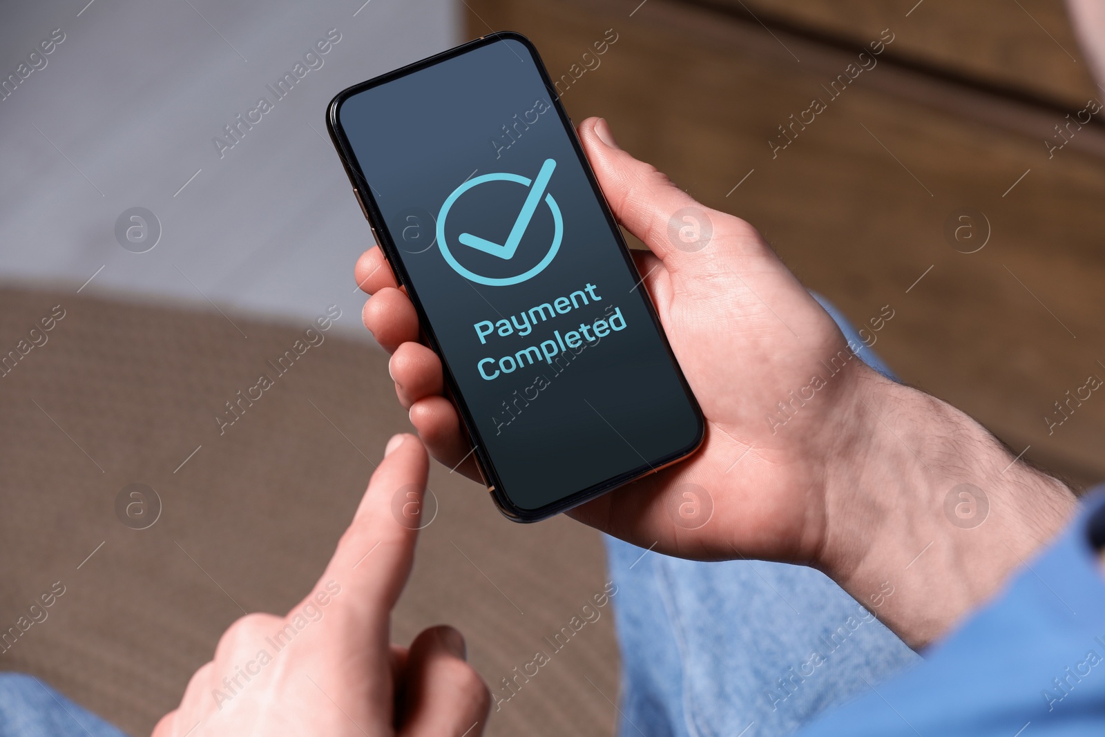 Image of Man successfully made payment using online banking application on smartphone indoors, closeup