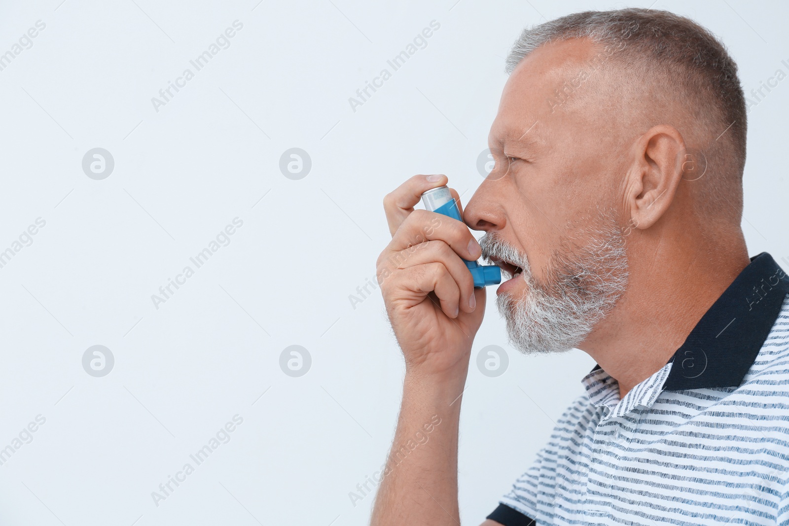 Photo of Man using asthma inhaler on white background