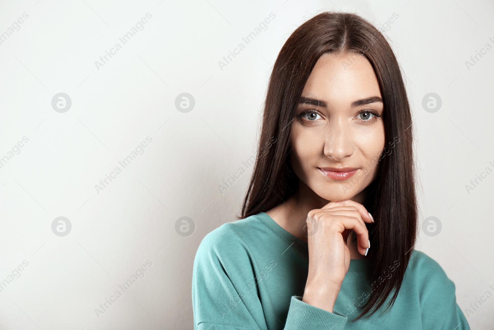 Photo of Portrait of pretty young woman with gorgeous chestnut hair on light background, space for text