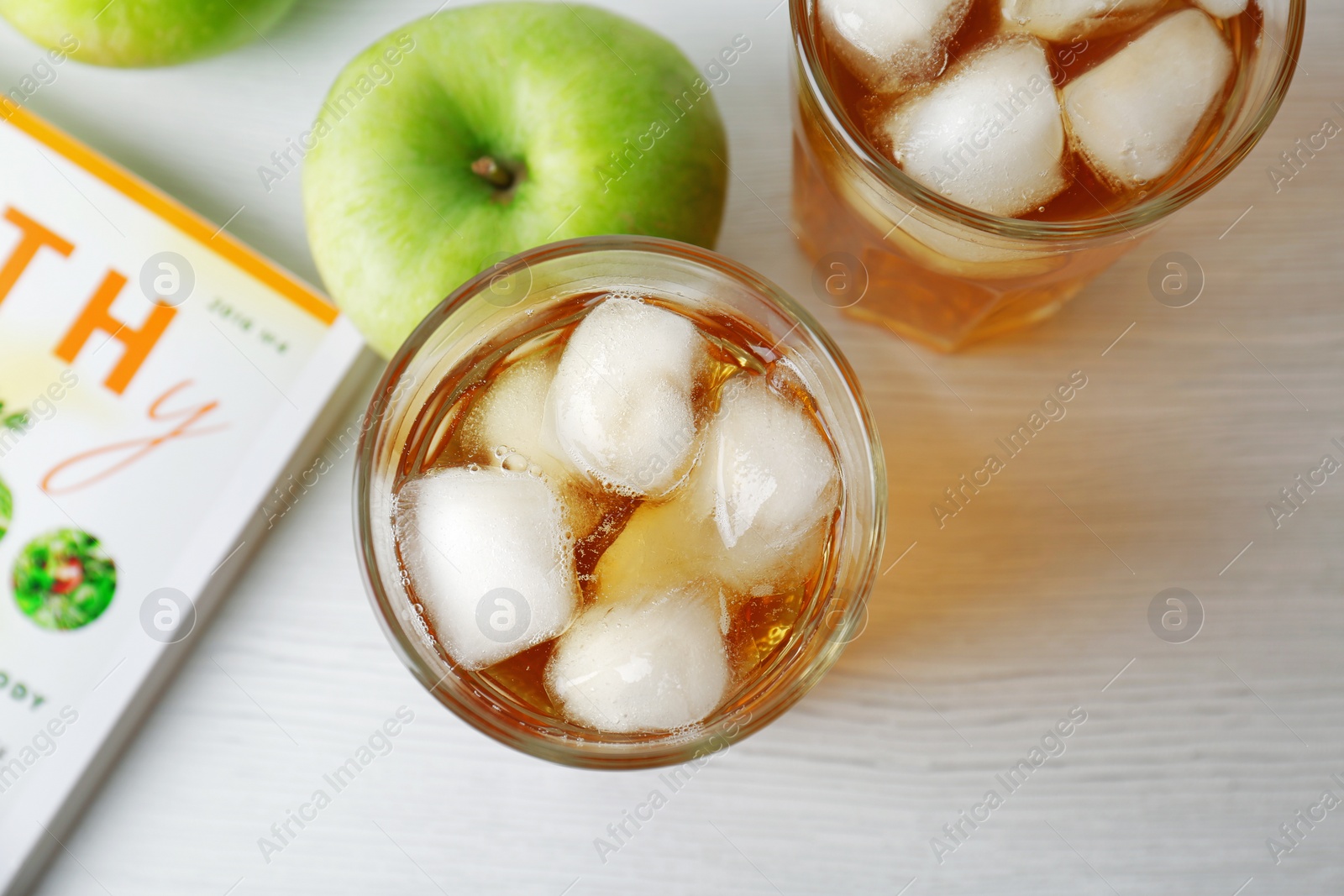 Photo of Two glasses of fresh apple juice with ice on table, top view