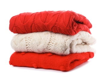 Photo of Stack of folded knitted sweaters on white background