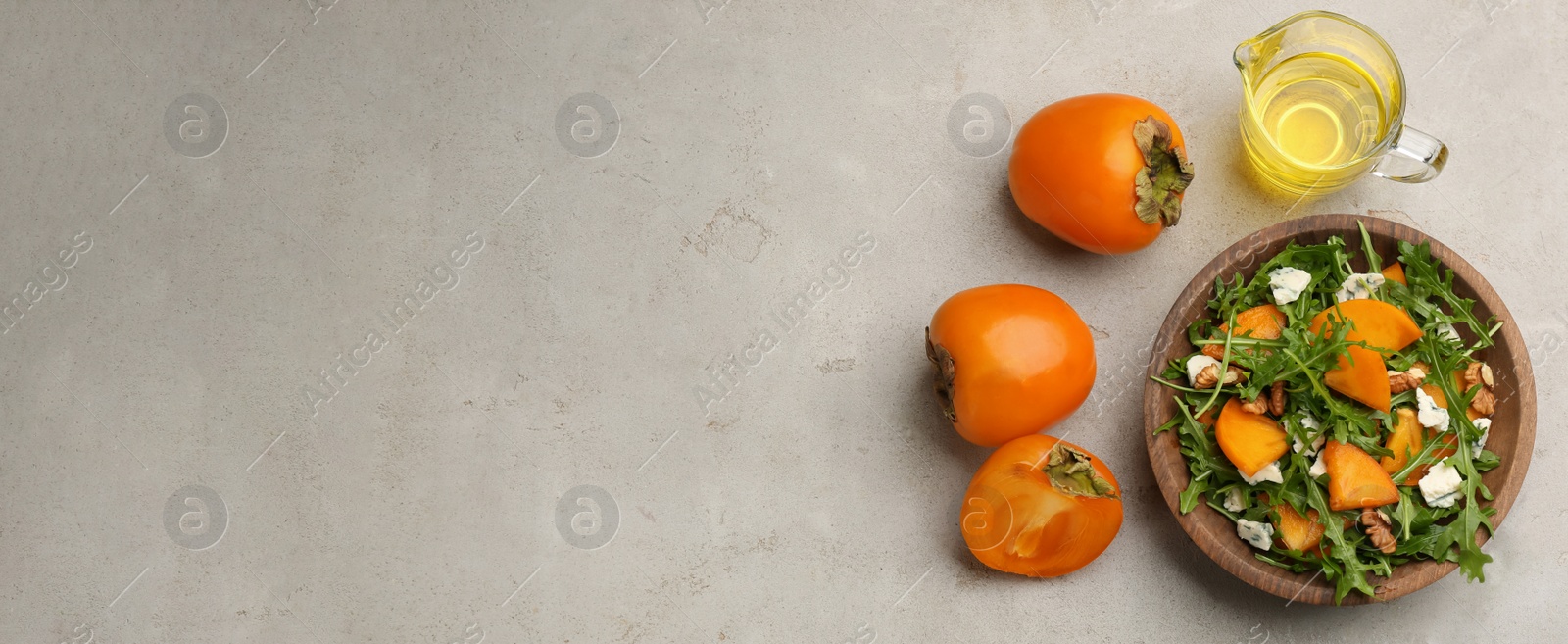 Photo of Delicious persimmon salad served on light grey table, flat lay. Space for text