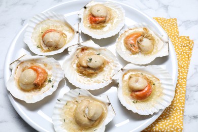 Photo of Fried scallops in shells on white marble table, above view