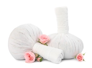 Photo of Herbal massage bags and beautiful roses on white background. Spa supply