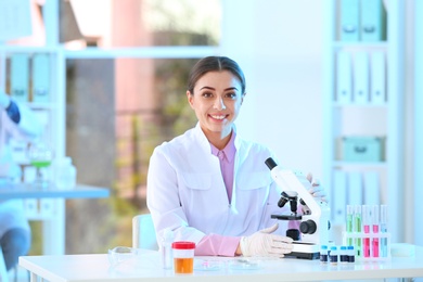 Young scientist with microscope in laboratory. Chemical analysis