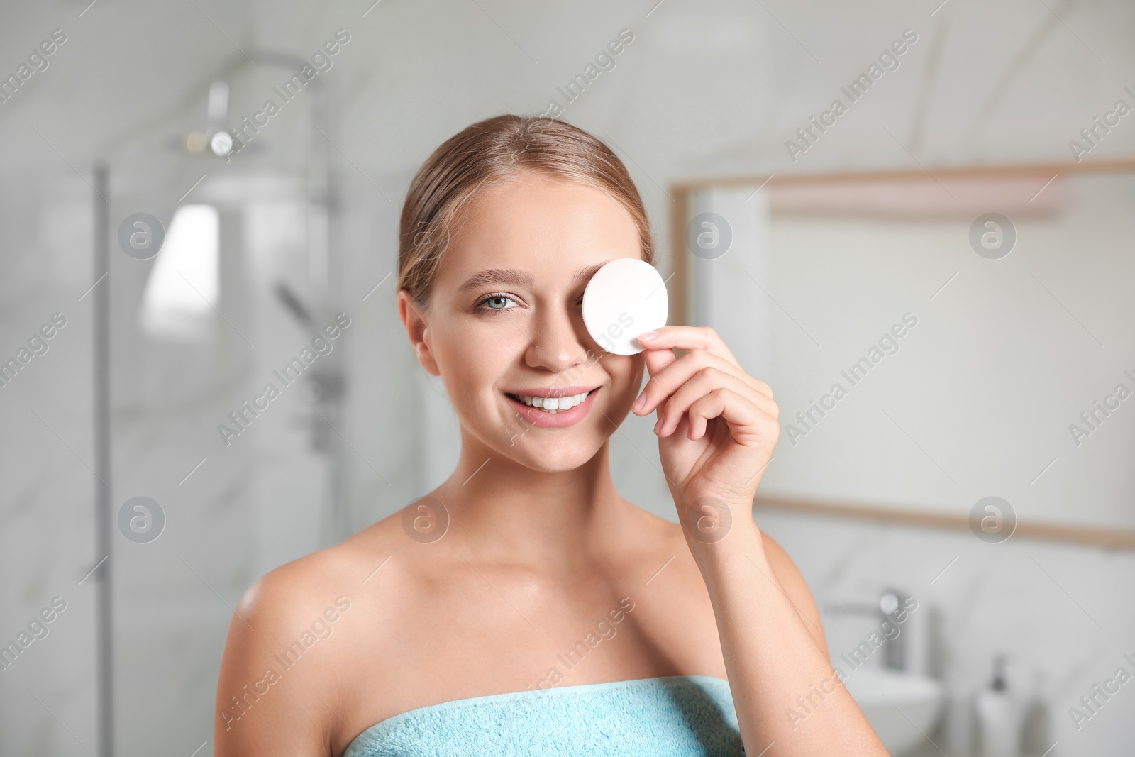 Photo of Beautiful young woman with cotton pad indoors