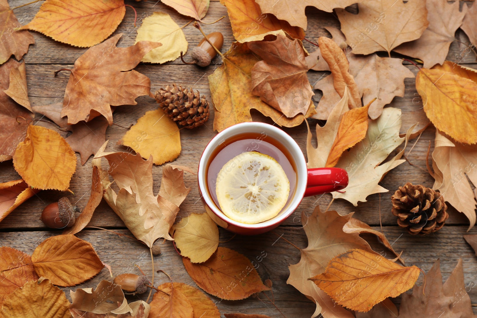 Photo of Flat lay composition with cup of hot drink on wooden table. Cozy autumn atmosphere