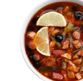 Meat solyanka soup with sausages, olives and vegetables in bowl isolated on white, top view