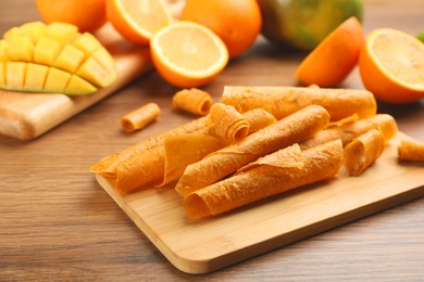 Composition with delicious fruit leather rolls on wooden table