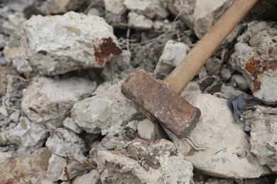 Photo of Sledgehammer on pile of broken stones outdoors, above view