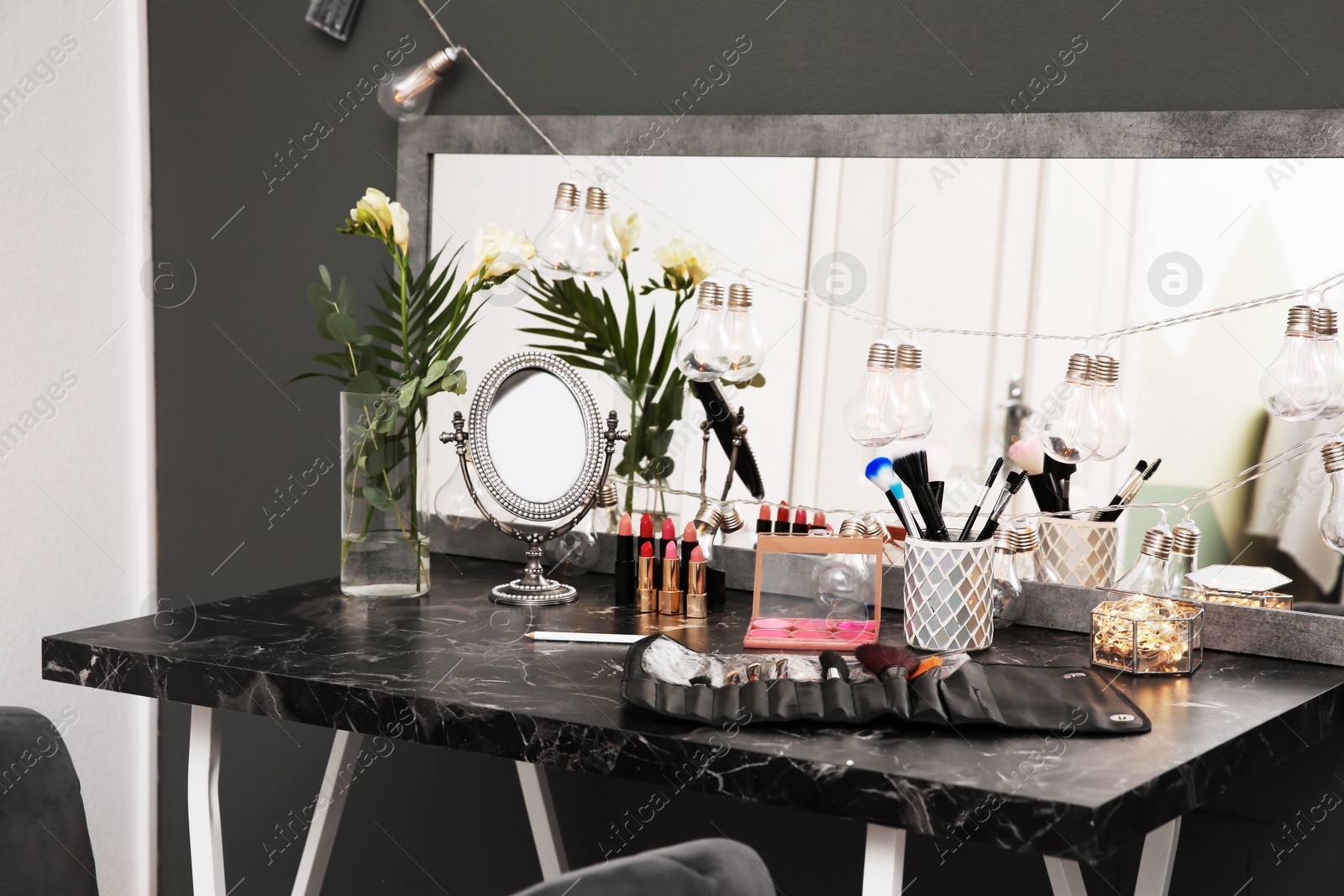 Photo of Decorative cosmetics and tools on dressing table in makeup room