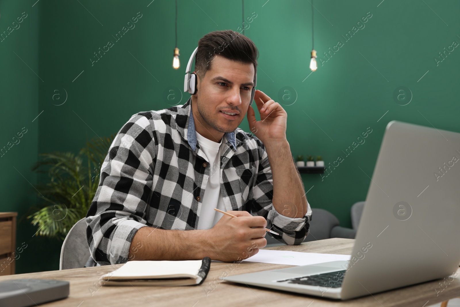 Photo of Man drawing with paints at online lesson indoors. Distance learning