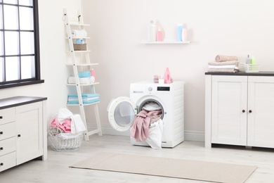 Photo of Bathroom interior with dirty towels in washing machine