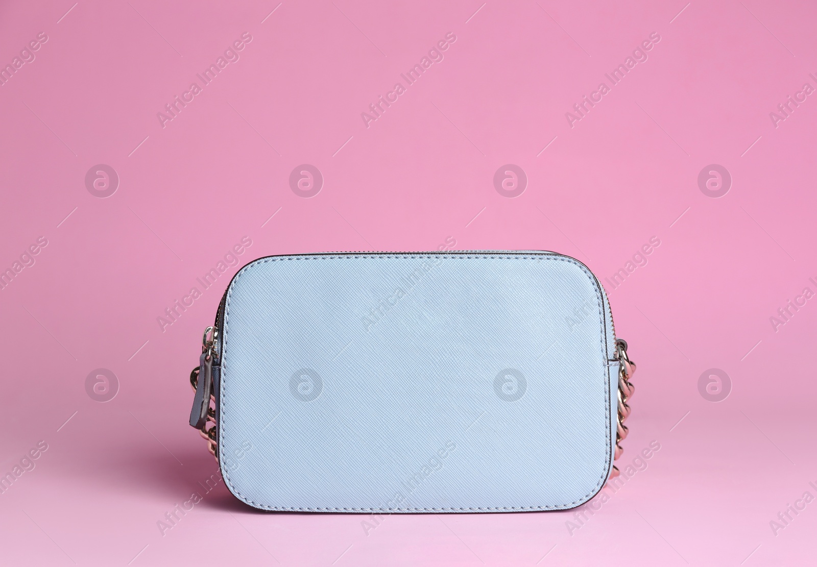 Photo of Stylish woman's bag on light pink background