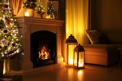 Photo of Stylish living room interior with beautiful fireplace, Christmas tree and other decorations at night