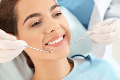 Dentist examining patient's teeth in modern clinic