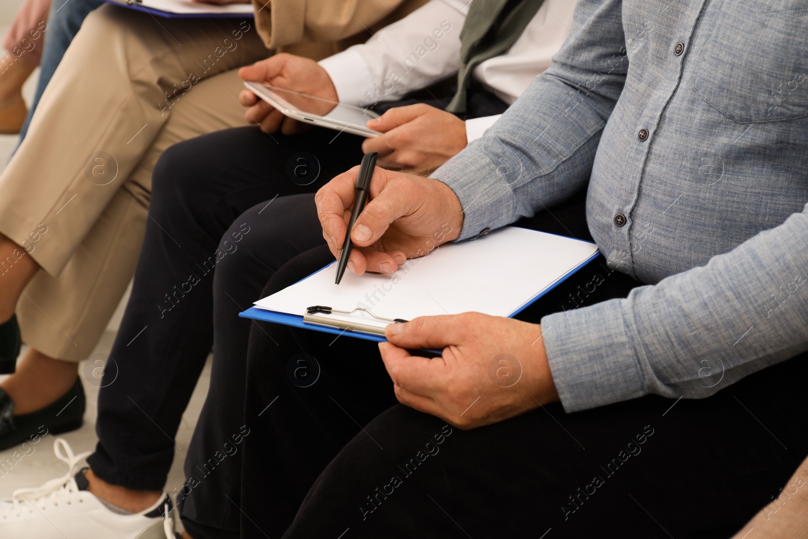 Photo of Man with clipboard waiting for job interview in office, closeup