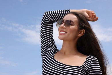 Photo of Beautiful smiling woman wearing stylish sunglasses outdoors