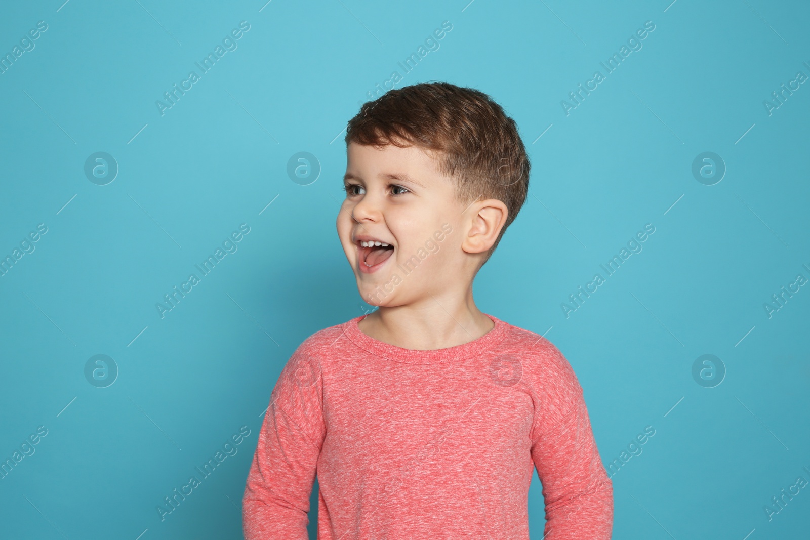 Photo of Portrait of little boy laughing on color background