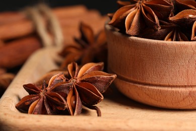 Photo of Aromatic anise stars on wooden board, closeup