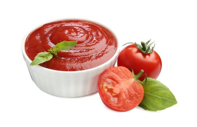 Photo of Tasty ketchup in bowl, basil and fresh tomatoes isolated on white