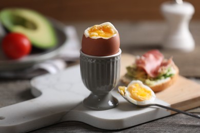 Photo of Soft boiled chicken egg served on wooden table