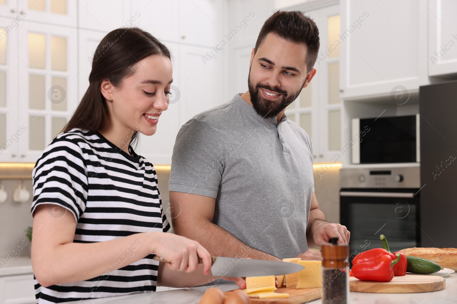 Photo of Lovely young couple cooking together in kitchen