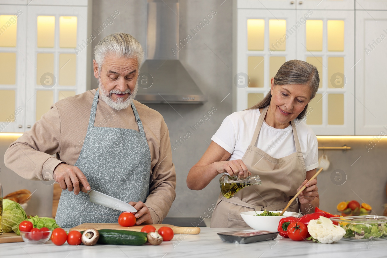 Photo of Happy senior couple cooking together in kitchen