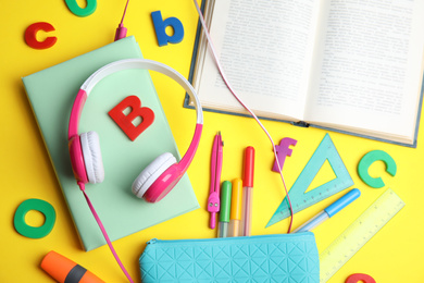 Flat lay composition with books and stationery on yellow background